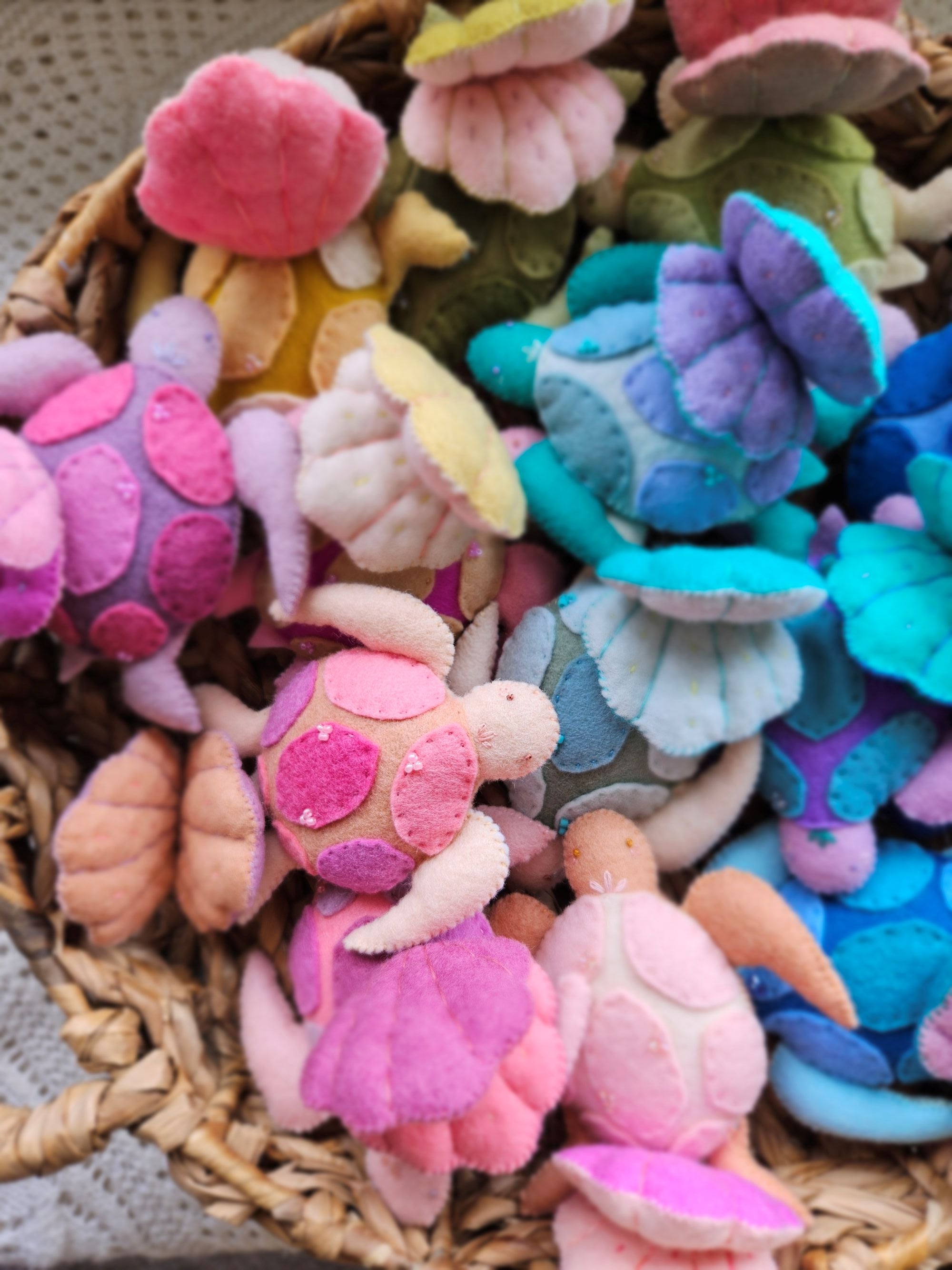 Colorful wool felt sea turtles in a woven basket