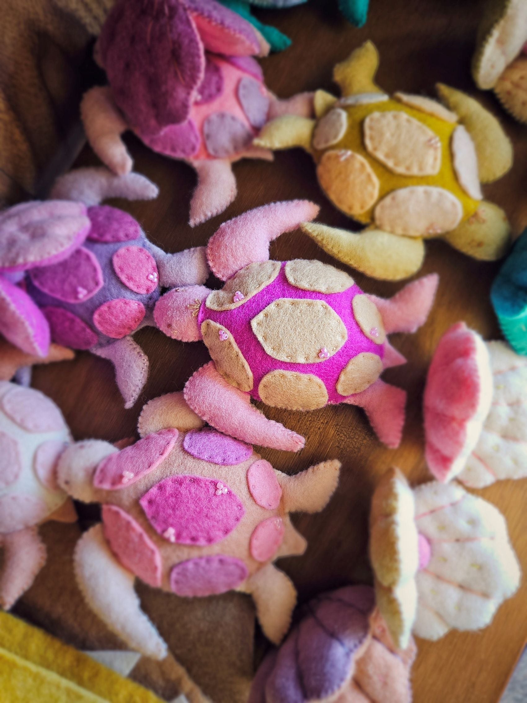 Colorful wool felt turtle toys on a wooden surface