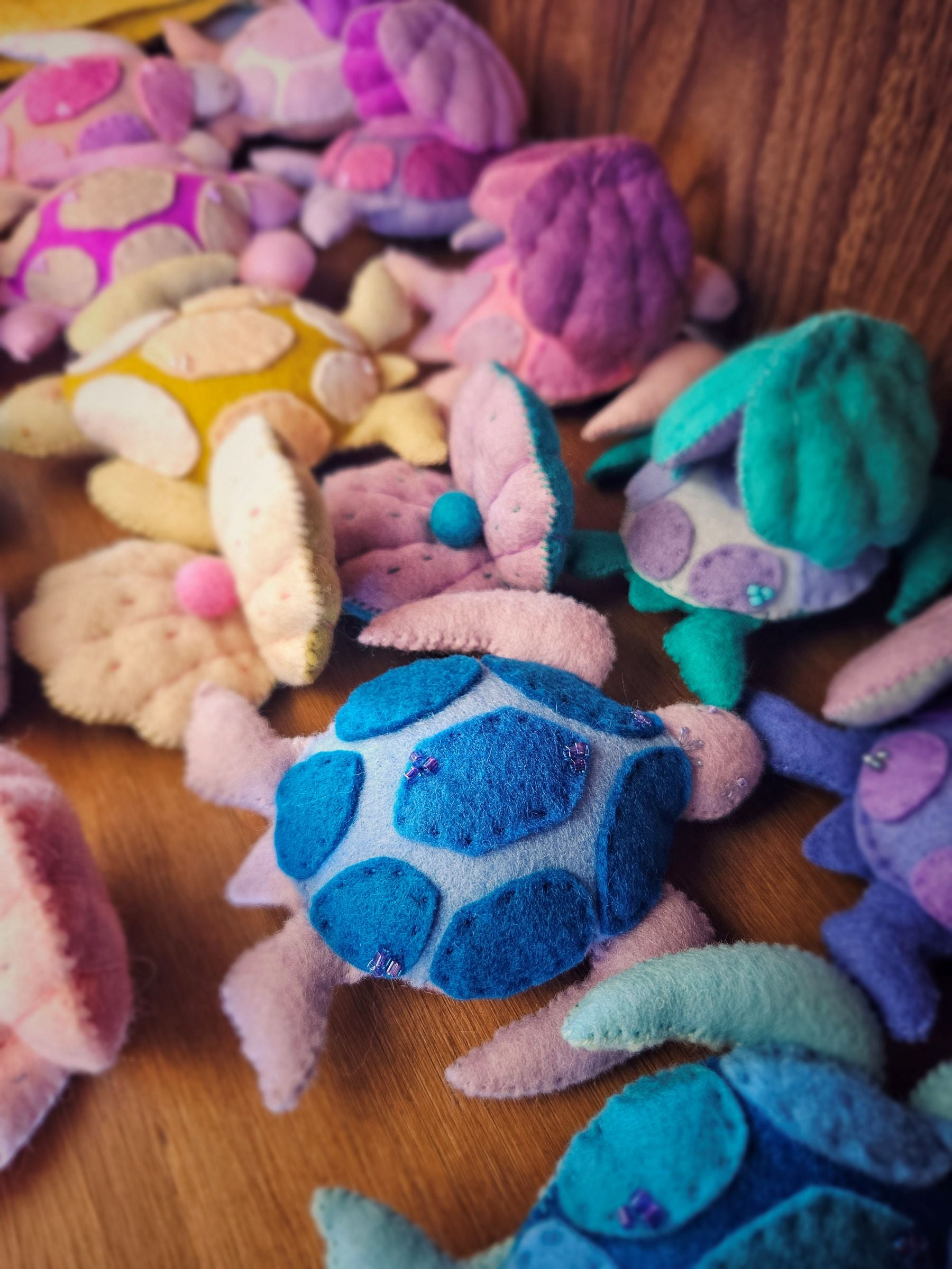 Colorful plush turtle toys on a wooden surface