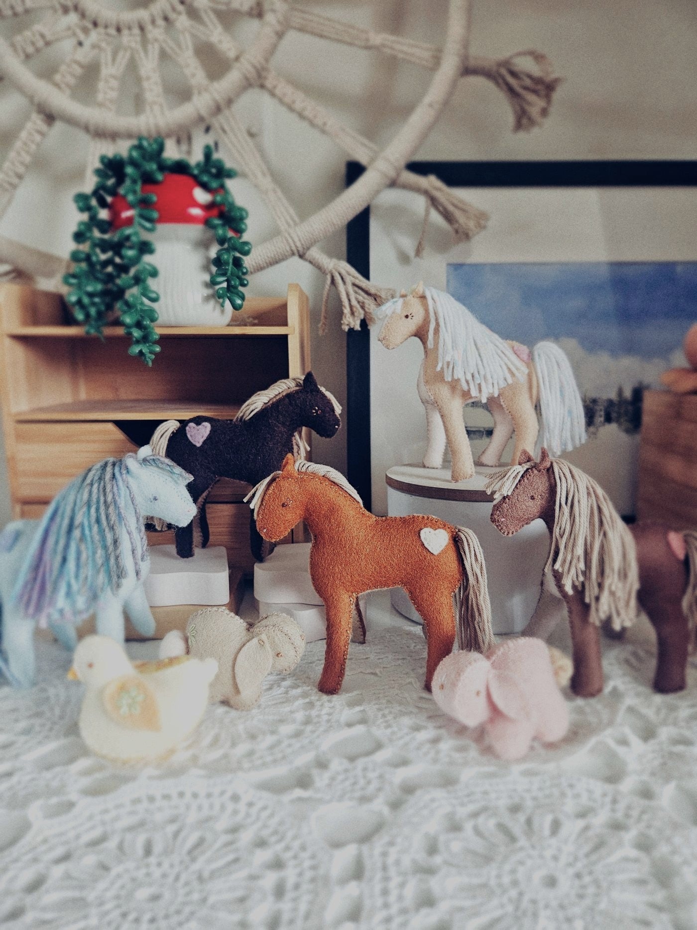Collection of handmade toy horses in a cozy room setting.