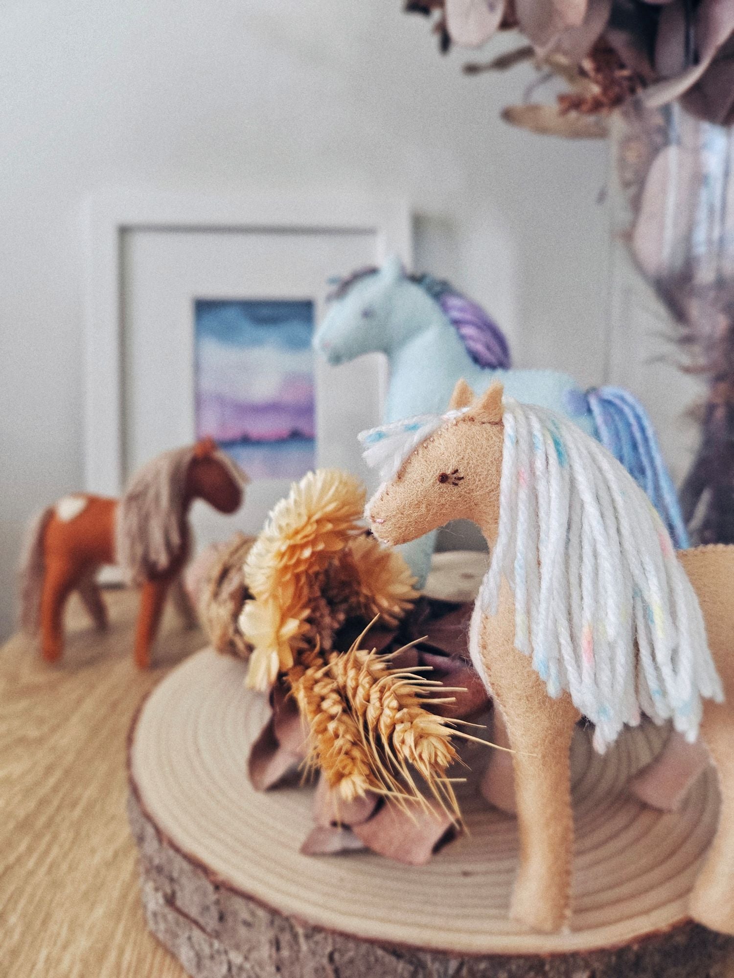 Decorative scene with felt horse toys in a play setting.