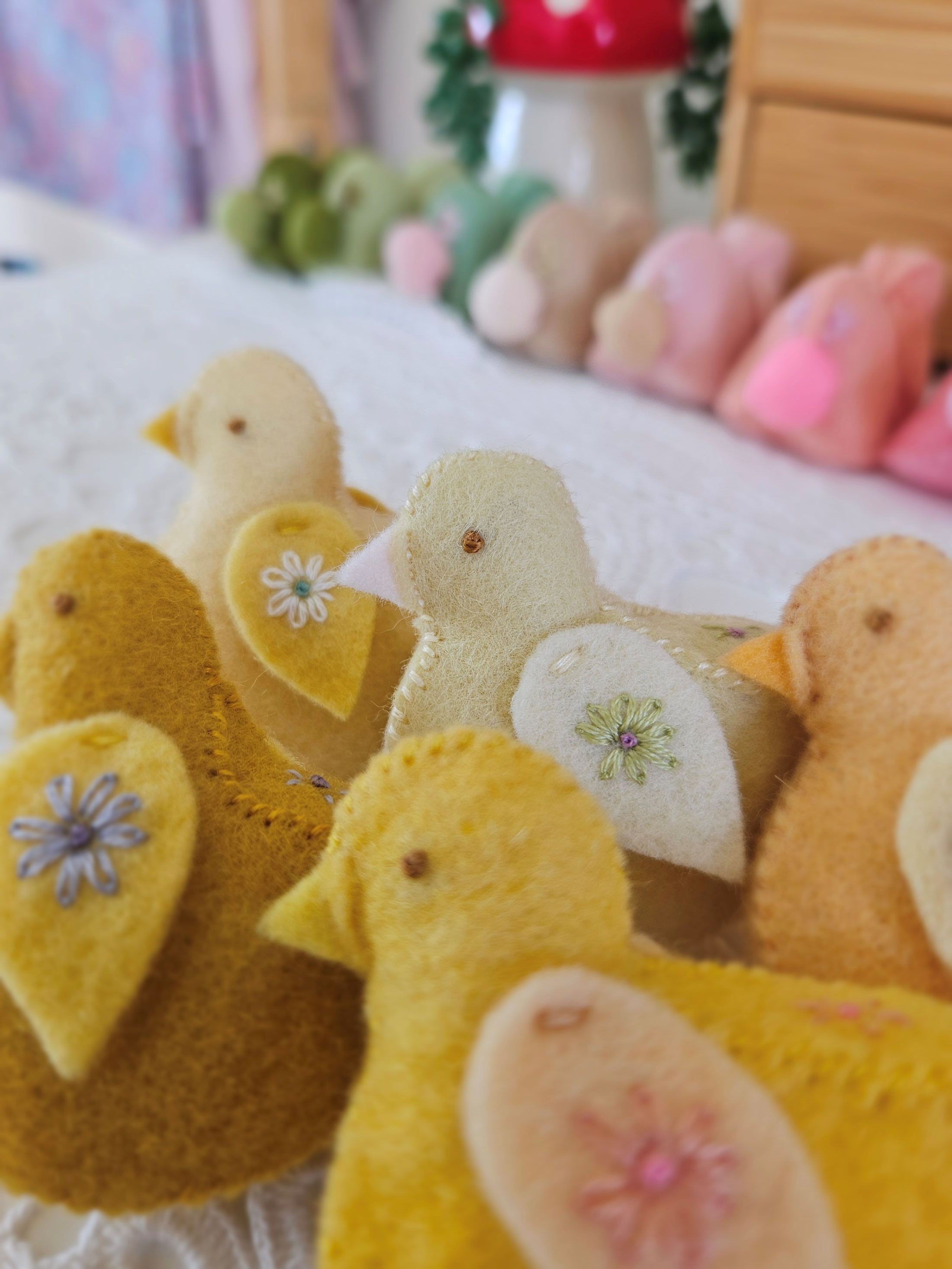 Stack of yellow and brown fabric chickens with floral patterns on a blurred background