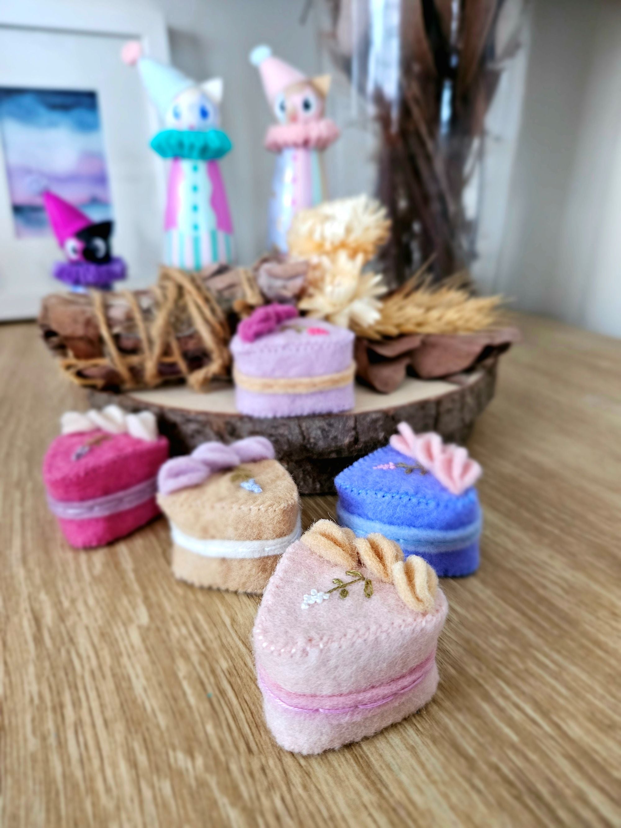 Small decorative cakes on a wooden surface with a blurred background